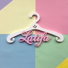 the word lavya is hanging from a hanger on a multi - colored background