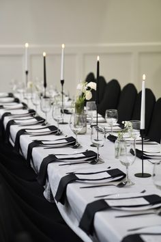 a long table with black and white place settings