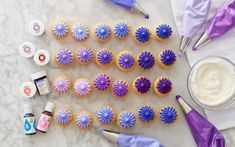 the cupcakes are decorated with purple and blue icing, along with other decorations