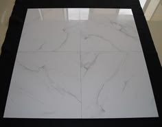 a white marble tile floor with black border