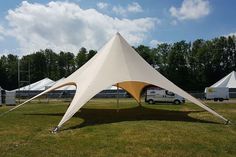 a large white tent sitting on top of a lush green field