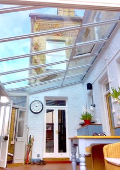 the inside of a house with a clock on the wall and skylight above it