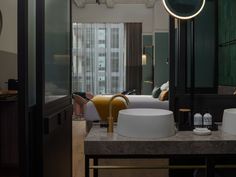 a bathroom with two sinks and a large mirror in the corner next to a bed