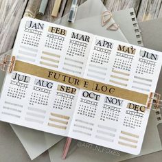 two calendars on top of each other next to some pens and paper with writing