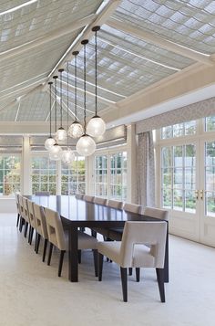 an elegant dining room with large windows and chandelier