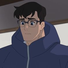 a man wearing glasses and a hoodie looks at the camera while staring into the distance