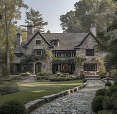 a large stone house surrounded by trees and bushes