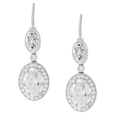 The stunning antique cut diamonds in these earrings are a testament to the craftsmanship and artistry of a bygone era, and highlight the unique beauty and character of antique diamonds. The two largest ovals weigh 1.01 carats each, and are certified by the GIA as a G IF and a G VVS2. The pair of oval tops weighs a total of 0.84 carats, and are approximately G color and VVS clarity. All four of the ovals have beautiful open culets and the distinctive charm of an old stone. The platinum mounting is modern, but its antique-inspired design accentuates the beauty of the diamonds and allows them to take center stage. The simple and elegant mounting is embellished with 0.23 carats of round diamonds, adding a touch of extra sparkle and sophistication to the design. Made in New York. Luxury Oval Diamond Earrings For Formal Events, Luxury Oval Diamond Earrings For Formal Occasions, Luxury Hallmarked Oval Diamond Earrings, Luxury Oval Diamond White Diamond Earrings, Luxury White Gold Oval Diamond Earrings, Luxury Oval Diamond Earrings With Accents, Luxury Oval Diamond Earrings For Anniversary, Luxury Oval Bridal Earrings For Formal Occasions, Luxury Oval White Gold Diamond Earrings