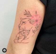 a woman with a tattoo on her arm holding a small cat and flower in it