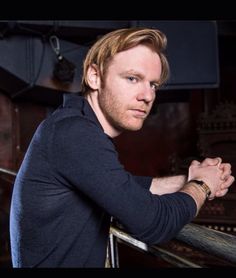 a man standing with his arms crossed and looking at the camera