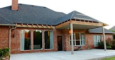 a brick house with an attached porch and covered patio