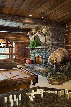 a bear statue is in the middle of a game room with pool table and foosball