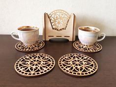 three cups and saucers sitting on top of a wooden table next to a box