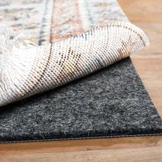 a close up of a rug on a wooden floor with a white and black carpet