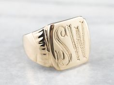 "This vintage signet ring has a beautiful monogram! Finally engraved accents and a stylish script provide a great focal point for this statement ring. We've left the original engraving on the inside as well, \"1955\", as a sweet reminder of the ring's history. Metal: 14K Yellow Gold Top Measurements: 14 x 15 mm, Rectangle Monogram: \"SW\" in Bold Font Ring Size: 9 Marks: \"1955 14K ME\" Stamped on the inside band SKU #: AF72NLMU Each piece has been identified and graded by a Graduate Gemologist Luxury Gold Square Cut Signet Ring, Luxury Antique Signet Ring Stamped 925, Luxury Art Deco Signet Ring For Anniversary, Luxury Oval Art Deco Signet Ring, Signet Rings Women Vintage, Signet Rings Women, Signet Ring Men, Monogram Ring, Signet Rings