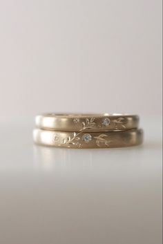 two gold wedding bands with diamonds on them