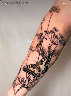 a woman's arm with a butterfly and flowers on it