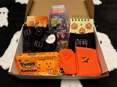 an open box with halloween items inside on a black and white carpeted flooring