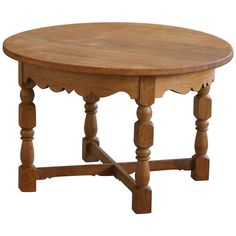 an oval wooden table with scalloped legs and a wood top, on a white background