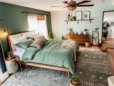 a bed room with a neatly made bed and a ceiling fan