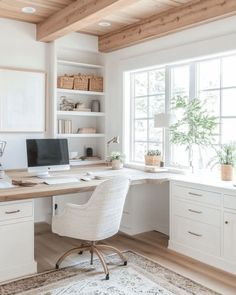 a home office with white furniture and wood beams on the ceiling, along with an area rug