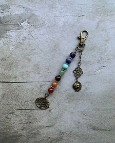 a key chain with charms on it sitting on top of a cement floor next to a wall