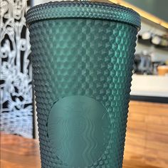 a starbucks cup sitting on top of a wooden table