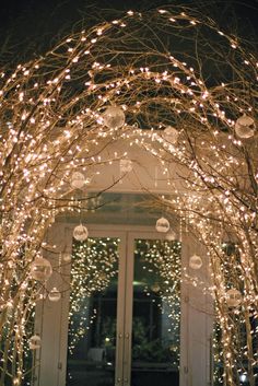 an archway decorated with christmas lights and ornaments