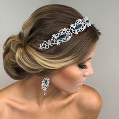 a woman wearing a bridal hair comb with crystal stones in the center and an intricate headband