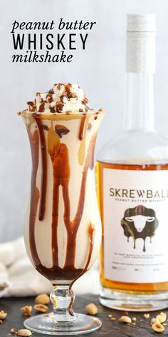 an ice cream sundae in a glass next to a bottle of whiskey and nuts