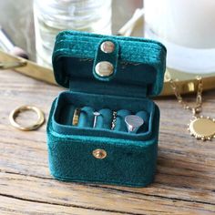 an open jewelry box sitting on top of a wooden table