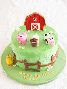 a green birthday cake with farm animals on it