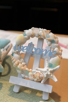 a welcome sign with seashells and starfish in the shape of a wreath