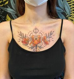 a woman wearing a face mask with flowers on her chest and behind her is a black tank top