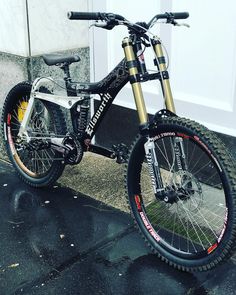 a bike parked in front of a door on a rainy day with no one around