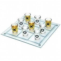 a set of shot glasses on top of a glass tray with x and o symbols