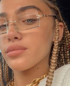 a woman with braids and glasses looking at the camera