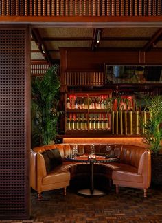 a corner booth with leather seating and plants