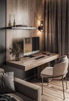 a desk with a computer on top of it in front of a couch and chair