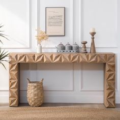 a wooden table sitting on top of a rug next to a vase and potted plant