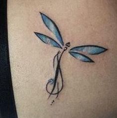 a blue dragonfly tattoo on the back of a woman's shoulder