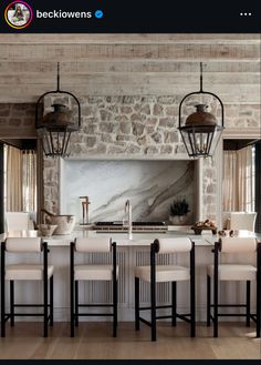 an image of a kitchen setting with marble counter tops and island in the middle that has four chairs around it