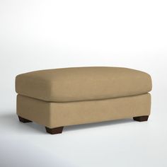 a tan ottoman sitting on top of a white floor