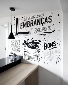 a kitchen wall painted with black and white lettering on it's side, next to a counter