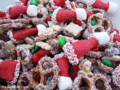 a white plate topped with lots of candy covered pretzels and marshmallows