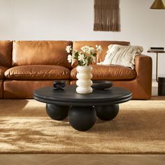 a living room filled with furniture and a large brown couch in front of a wooden coffee table