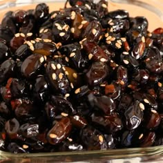 a glass bowl filled with raisins on top of a table