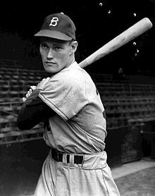 an old black and white photo of a baseball player holding a bat in his hands