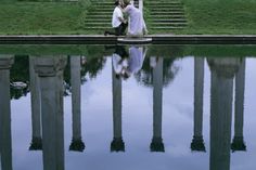 a man and woman sitting next to each other near water