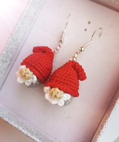 two crocheted santa hats hanging from earrings